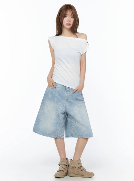 Leopard Print Jorts IU525 Light blue full-body front shot on model hands in pockets wearing white asymmetric off-shoulder top and chunky beige sneakers