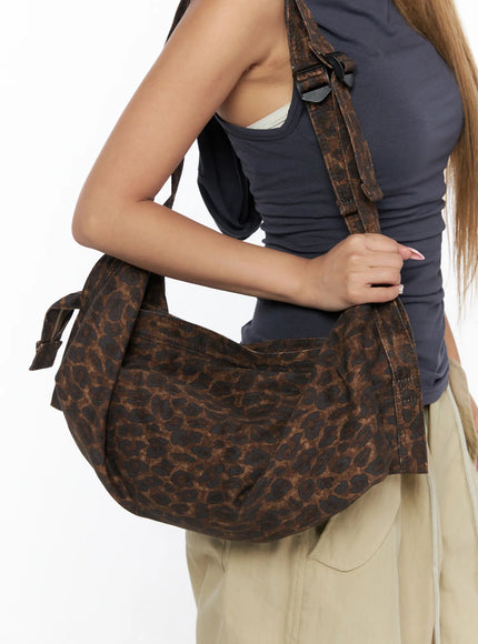 Leopard Print Sling Shoulder Bag CU524 Brown close-up detail shot of bag body resting against model hip showing crescent shape and leopard print texture