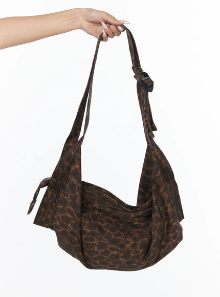 LEWKIN Leopard Print Sling Shoulder Bag CU524 Brown One Size hand-held product shot showing crescent silhouette with black buckle hardware and leopard textile