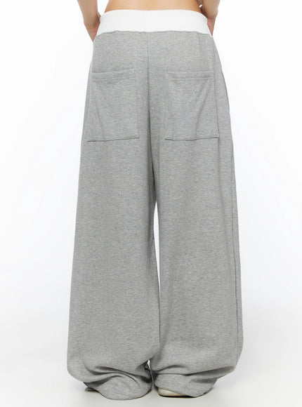 Lettering Contrast Waist Sweatpants IL515 Gray back close-up on model showing white contrast waistband, two large patch pockets, and wide-leg pooling hem on gray marl fleece