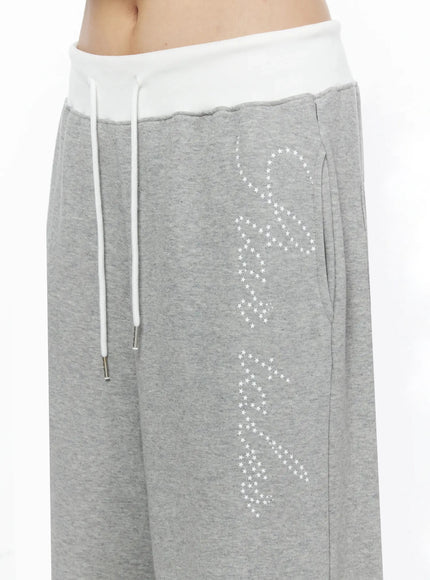 Lettering Contrast Waist Sweatpants IL515 Gray close-up detail of white contrast waistband, white rope drawstring, and star-dot script lettering on gray marl fleece fabric