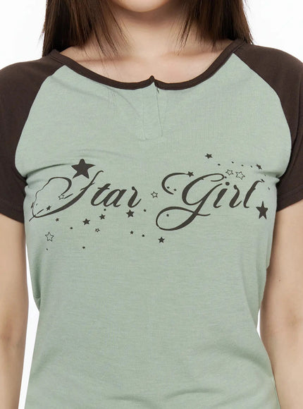 Lettering Raglan Slit Short Sleeve Tee IL515 Mint close-up detail shot showing Star Girl cursive script print star motifs and notch neckline with brown contrast trim