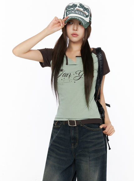 LEWKIN Lettering Raglan Slit Short Sleeve Tee IL515 Mint front angled shot on model wearing cap and leather bag styled with wide-leg jeans