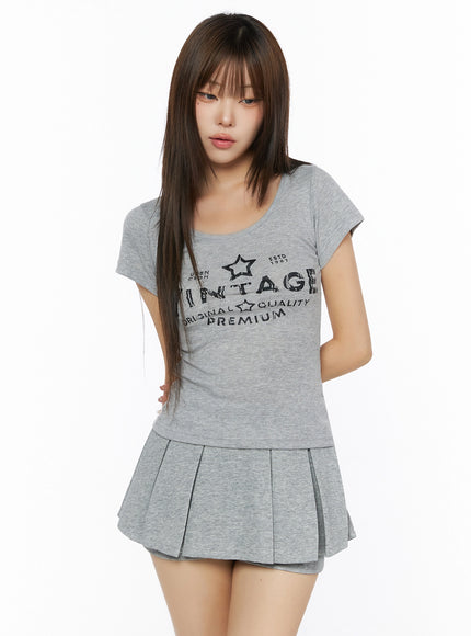 Lettering U-Neck Slim Short Sleeve Tee IL515 Grey front shot on model with slim fit silhouette paired with matching grey pleated mini skirt