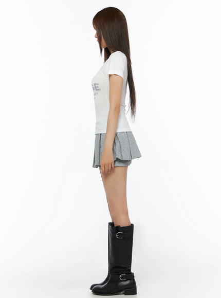 Lettering U-Neck Slim Short Sleeve Tee IL515 White side shot on model showing slim silhouette and short sleeve length paired with grey pleated skirt and boots