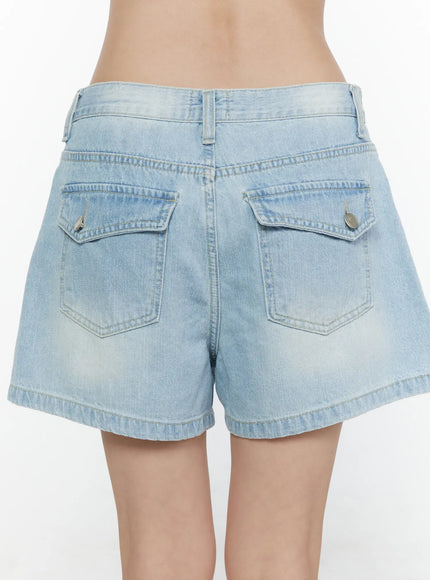 Light Washed Denim Shorts CL520 Light blue close-up back shot on model showing dual flap pockets with silver stud buttons and faded denim stitching
