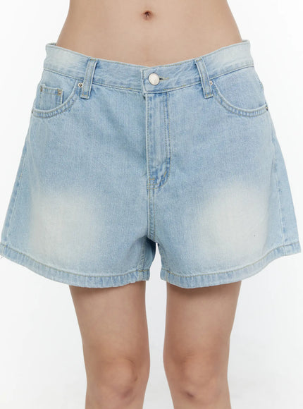 Light Washed Denim Shorts CL520 Light blue close-up front shot on model showing waistband silver button front pockets and sun-faded denim detail