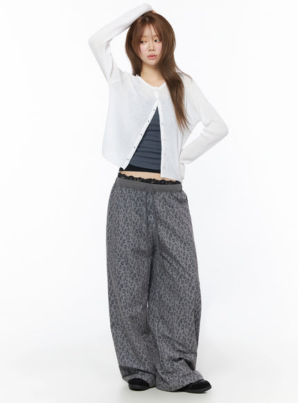 Lightweight Knit Cardigan IU525 White three-quarter front shot on model hand on head, sheer ribbed knit open cardigan styled with leopard wide-leg pants