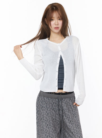 Lightweight Knit Cardigan IU525 White front shot on model touching hair, sheer open-front ribbed knit cardigan with pearl-style buttons over gray ribbed tank
