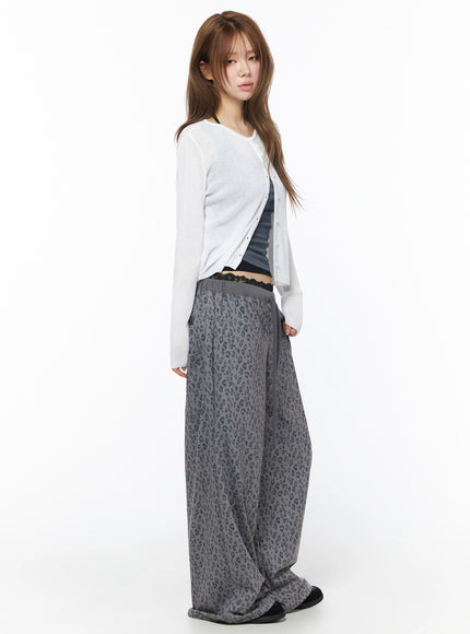 Lightweight Knit Cardigan IU525 White side shot on model, sheer ribbed knit open cardigan showing sleeve length paired with gray leopard wide-leg pants