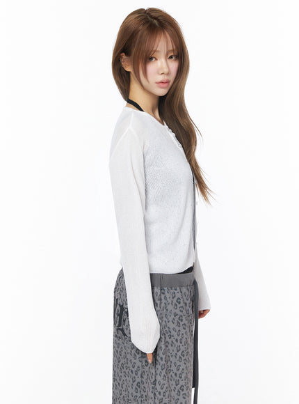Lightweight Knit Cardigan IU525 White side profile shot on model with straight hair, sheer ribbed knit cardigan showing sleeve and hem line with leopard pants