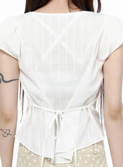 Linen Summer Blouse IL506 White close-up back detail shot showing back tie bow at waist and vertical stripe semi-sheer woven fabric texture