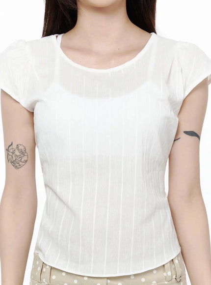 Linen Summer Blouse IL506 White close-up front detail shot on model showing round neckline, cap sleeves and vertical stripe woven texture