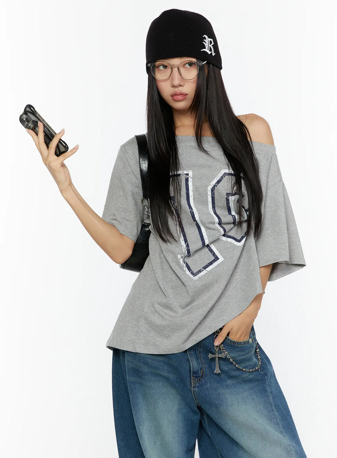 LEWKIN Loose Fit Oversized Tee CU526 Gray half-body front shot on model wearing black beanie and glasses holding phone, off-shoulder styling with navy number 10 distressed print
