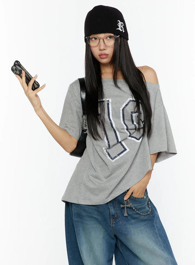 LEWKIN Loose Fit Oversized Tee CU526 Gray half-body front shot on model wearing black beanie and glasses holding phone, off-shoulder styling with navy number 10 distressed print