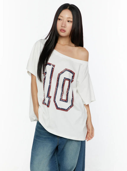 Loose Fit Oversized Tee CU526 White front shot on model with one shoulder exposed, large distressed red and navy number 10 graphic print, paired with wide-leg jeans