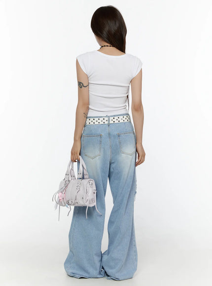 Lou Distressed Wide Leg Jeans CL508 Light blue back styled shot on model holding mini bag showing rear pockets and star-studded belt