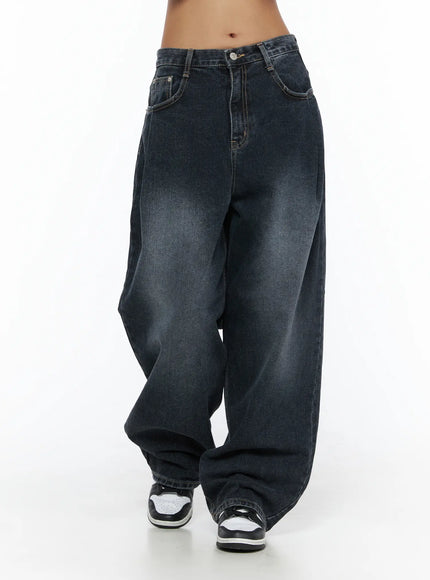Louis Pintuck Washed Jeans CL503 Dark blue front view on model, washed indigo wide-leg jeans with pintuck pleats, low rise, and stacked hem over sneakers