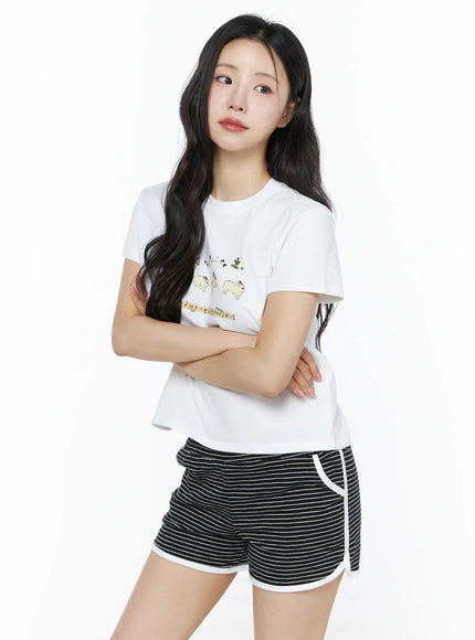 Lovely Bunny Graphic Tee IU525 White three-quarter front shot on model arms crossed showing bunny graphic tee with cropped boxy cotton silhouette