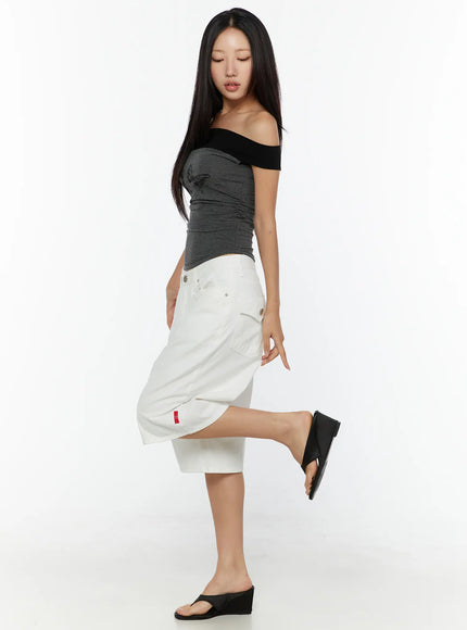 Low-Rise Cotton Shorts CU529 White side view on model posing with one leg raised showing snap-button side pocket red label and wide-leg cotton fabric
