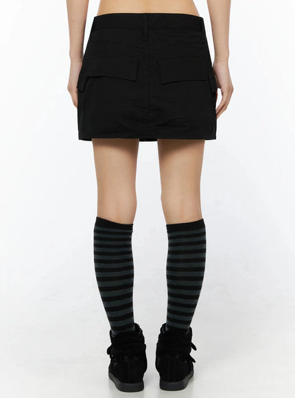 Low Rise Crinkle Cargo Skort IL509 Black back shot on model showing rear cargo pockets straight hem striped knee socks black sneakers paired with graphic tank
