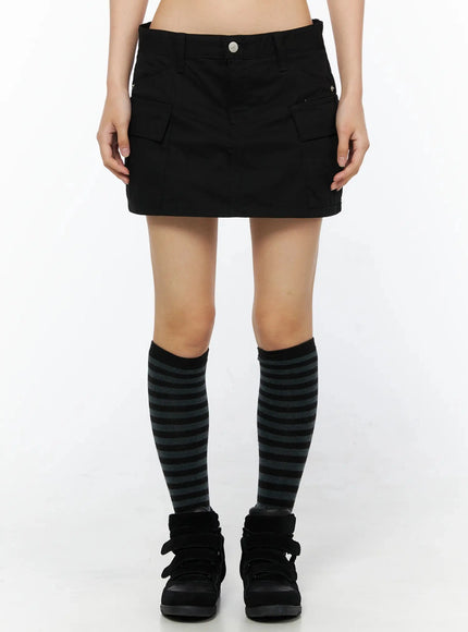 LEWKIN Low Rise Crinkle Cargo Skort IL509 Black front shot on model cropped at waist showing cargo pockets silver button waistband striped knee socks black sneakers