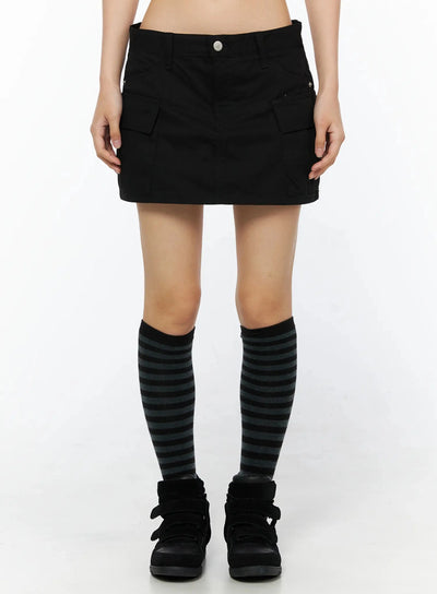 LEWKIN Low Rise Crinkle Cargo Skort IL509 Black front shot on model cropped at waist showing cargo pockets silver button waistband striped knee socks black sneakers