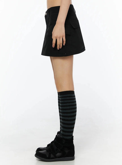 Low Rise Crinkle Cargo Skort IL509 Black pure side shot on model showing silhouette side cargo pocket silver snap button low rise waistband black sneakers