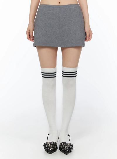 LEWKIN Low-Rise Mini Skort IU525 Gray S/M front close-up on model showing low-rise waistband and heathered cotton mini skirt length with white knee-high socks