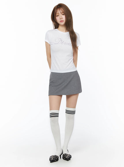 Low-Rise Mini Skort IU525 Gray full-body front shot on model standing straight, styled with white rhinestone crop tee and white striped over-knee socks