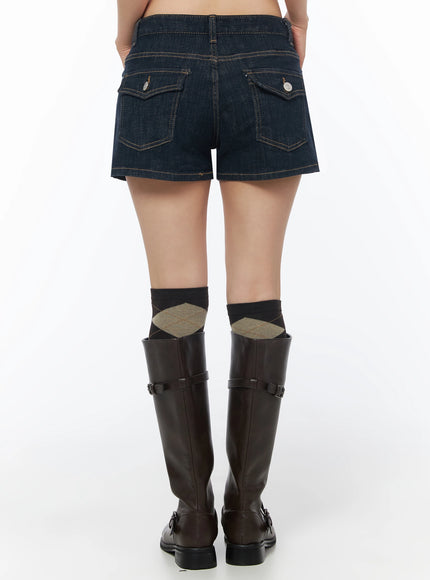 Low-Rise No-Fade Denim Shorts IU525 Dark blue back crop shot on model showing two flap pockets with silver buttons and contrast gold topstitching on dark denim