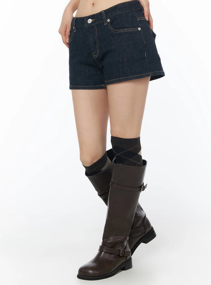 Low-Rise No-Fade Denim Shorts IU525 Dark blue side crop shot on model showing pocket detail, low-rise waistband, and contrast topstitching with riding boots