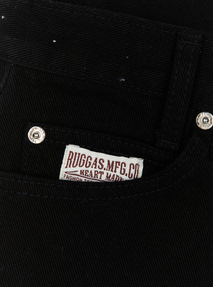 Low Rise Shorts IL521 Black close-up detail of RUGGAS.MFG.CO woven label on front pocket with silver rivet hardware on black twill denim fabric