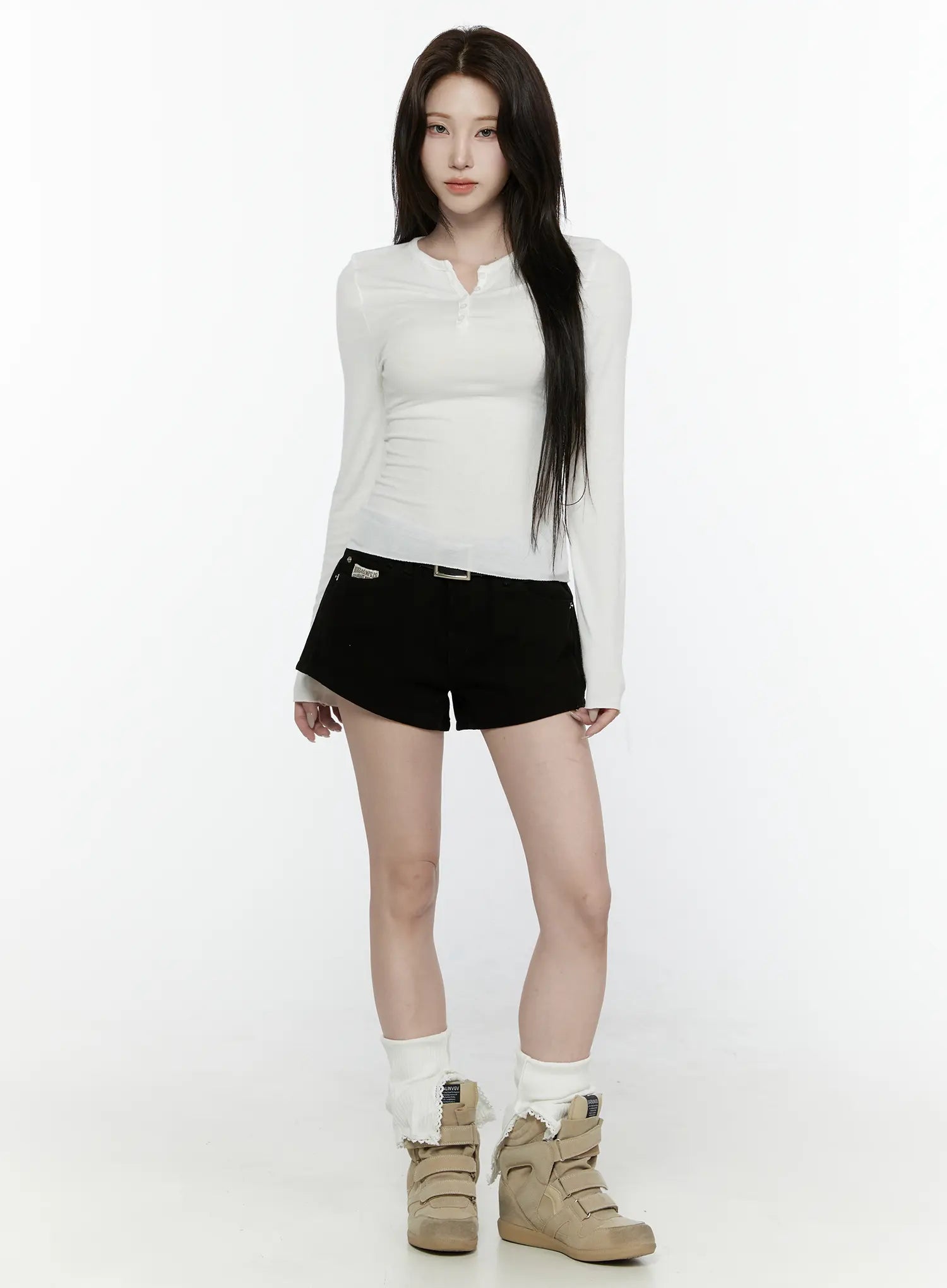 Low Rise Shorts IL521 Black front full-length shot on model styled with white long-sleeve top, silver belt, and white leg warmers with sneakers, standing upright