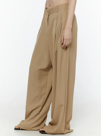Low-Rise Wide Leg Tailored Pants IL506 Beige side view on model showing pleated waistband zipper fly and wide fluid leg silhouette with sandals