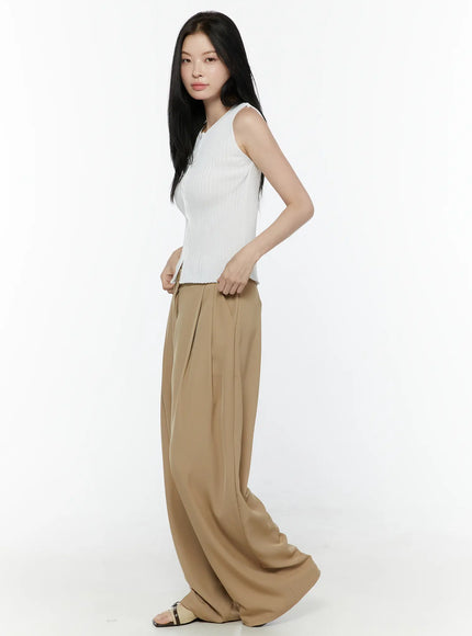 Low-Rise Wide Leg Tailored Pants IL506 Beige side view on model styled with white sleeveless ribbed top hands in pockets showing wide-leg drape