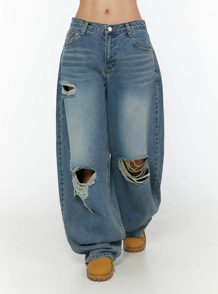 Mackenzie Blue Rip Jeans CU526 Blue front shot on model showing full-length wide balloon leg silhouette with large knee rips and tan boots