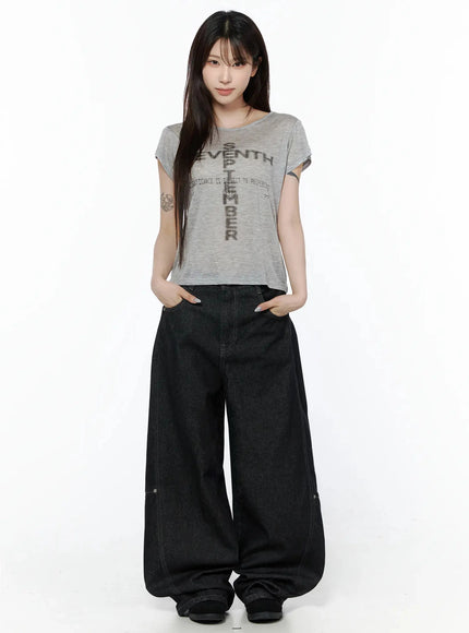 Maelani Rivet Wide Balloon Jeans IL502 Black full-body front shot on model hands in pockets wearing gray graphic tee, showcasing oversized balloon leg drape