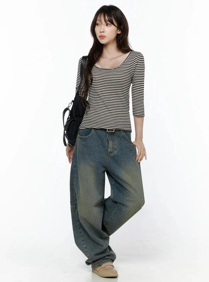 Marion Washed Wide-Leg Jeans IL506 Dark blue three-quarter front on model looking away, styled with striped top and black shoulder bag, wide-leg denim with belt