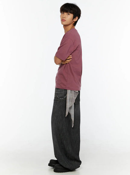 Men's Archive Graphic T-Shirt IL515 mauve side profile view on model arms crossed showing relaxed boxy cotton silhouette with shirt tied at waist