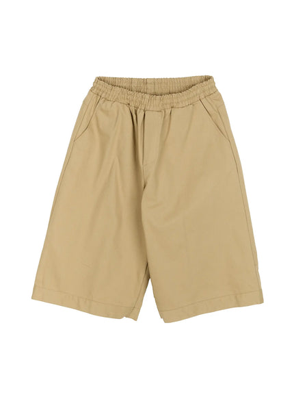 Men's Baggy Bermuda Shorts IL514 Beige flat-lay front view showing elastic waistband, wide-leg silhouette, side pockets, and cuffed hem on cotton twill fabric