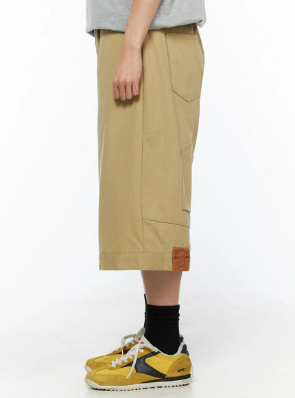 Men's Baggy Bermuda Shorts IL514 Beige side view on model showing front pocket detail, angular stitched cargo pocket, leather Original Jeans patch label at cuffed hem
