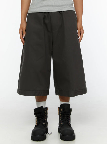 Men's Baggy Cargo Shorts (Dark Gray) IL515 Dark Gray front close-up on model showing wide-leg silhouette, drawstring waist, and cuffed hem with combat boots
