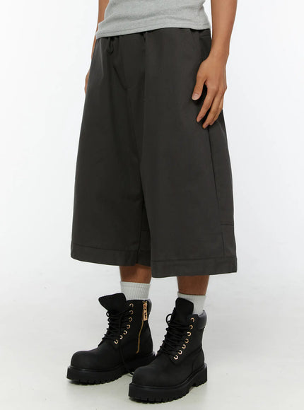 Men's Baggy Cargo Shorts (Dark Gray) IL515 Dark Gray side close-up on model highlighting wide-leg cut, side cargo pockets, cuffed hem, and leather label patch