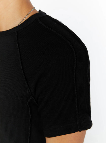 Men's Basic Ribbed T-Shirt IL509 Black close-up detail shot showing raglan shoulder seam exposed stitching ribbed fabric texture and rolled sleeve hem