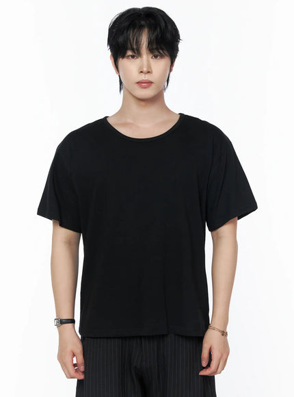 Men's Basic U-Neck T-Shirt IU523 Black close-up front shot on male model showing U-neckline boxy fit and smooth cotton fabric paired with pinstripe trousers