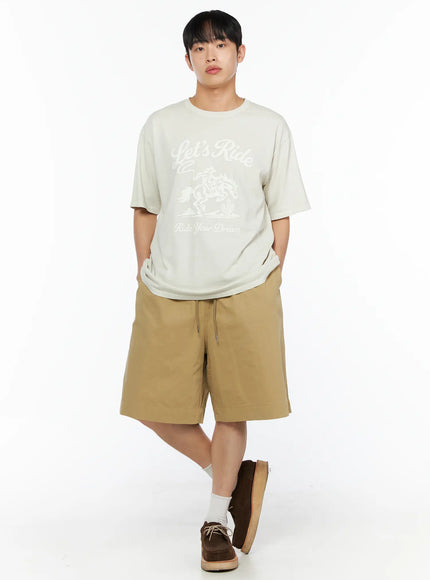 LEWKIN Men's Bermuda Shorts (Beige) IL514 beige full-body front shot on male model with hands in pockets styled with graphic tee and brown suede shoes