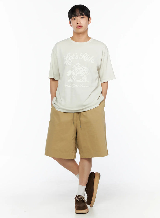 LEWKIN Men's Bermuda Shorts (Beige) IL514 beige full-body front shot on male model with hands in pockets styled with graphic tee and brown suede shoes