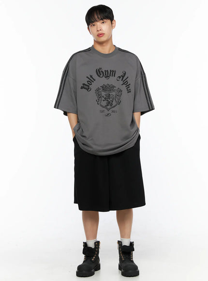 Men's Bermuda Sweat Shorts (Black) IL514 Black full-body front shot on male model hands in pockets, styled with grey Volt Gym Alpha oversized tee and black boots, relaxed fit