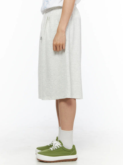 Men's Bermuda Sweat Shorts (Light Gray) IL514 Light gray side shot on model showing smooth melange fabric drape elastic waistband and below-knee length silhouette